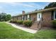 Brick home with stairs leading to front door, black shutters, and manicured bushes at 201 E Laramie Dr, Mebane, NC 27302