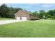 Charming home with an attached two-car garage on a well-maintained lawn and a wooded backdrop at 201 E Laramie Dr, Mebane, NC 27302