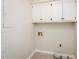 Functional laundry room with white cabinets, neutral walls, utility hookups, and tile floors at 201 E Laramie Dr, Mebane, NC 27302