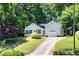 Charming home with a single-car garage, a driveway, and a yard surrounded by lush trees at 203 Needle Park Dr, Cary, NC 27513