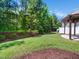 Landscaped backyard with green grass and mature trees, perfect for outdoor living at 205 Hammond Wood Pl, Morrisville, NC 27560