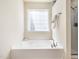 Bathroom featuring soaking tub and walk-in shower with bright natural light at 205 Hammond Wood Pl, Morrisville, NC 27560