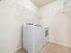 Laundry room with white washer and dryer units and wire shelving at 205 Hammond Wood Pl, Morrisville, NC 27560