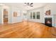 Open-concept living room featuring hardwood floors, a fireplace, and seamless flow to dining and kitchen areas at 205 Hammond Wood Pl, Morrisville, NC 27560