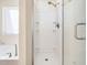 Walk-in shower with glass door next to a white tub with a light-filled window in bathroom at 205 Hammond Wood Pl, Morrisville, NC 27560