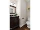 Stylish half bath with a dark wood vanity, granite countertop, modern fixtures, and decorative shelf at 206 Kettlebridge Dr, Cary, NC 27511