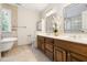 Bathroom with double vanity, soaking tub, travertine flooring, and separate lavatory at 206 Kettlebridge Dr, Cary, NC 27511