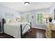 Comfortable bedroom with a white comforter, shuttered windows, hardwood floors, and soft, blue walls at 206 Kettlebridge Dr, Cary, NC 27511