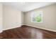 Bright, vacant bedroom with hardwood floors, a large window with views, and neutral paint at 206 Kettlebridge Dr, Cary, NC 27511