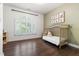 Bright Bedroom featuring a light wood crib, hardwood floors, and a window with plantation shutters at 206 Kettlebridge Dr, Cary, NC 27511