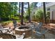 Backyard with a brick firepit and chairs surrounded by trees at 206 Kettlebridge Dr, Cary, NC 27511