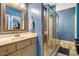 Bathroom features a glass enclosed shower, blue walls, and vanity with a modern sink at 2062 Montgomery Dr, Franklinton, NC 27525