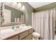 Well-lit bathroom with a large mirror, tiled shower, and white cabinets at 2062 Montgomery Dr, Franklinton, NC 27525