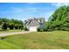 Landscaped yard with a traditional home, two-car garage and long drive under a blue sky at 2062 Montgomery Dr, Franklinton, NC 27525