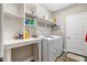 Bright laundry room with washer, dryer, utility sink and storage shelves at 2062 Montgomery Dr, Franklinton, NC 27525