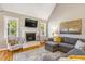 Bright living room features vaulted ceilings, hardwood floors, fireplace, and comfortable grey sectional sofa at 2062 Montgomery Dr, Franklinton, NC 27525