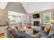 Open concept living room with fireplace and grey sectional sofa flowing into the kitchen area at 2062 Montgomery Dr, Franklinton, NC 27525