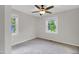 Bedroom featuring neutral walls, carpet, ceiling fan and two window with tree view at 207 Mcleod Dr, Sanford, NC 27330