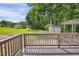 Wood deck with backyard view, featuring lush greenery and storage sheds, perfect for relaxation at 207 Mcleod Dr, Sanford, NC 27330