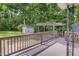 Large wooden deck offers an outdoor retreat, enhanced by a pergola and lush greenery at 207 Mcleod Dr, Sanford, NC 27330