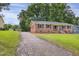 Exterior view of brick home, accented by a winding driveway and surrounding greenery at 207 Mcleod Dr, Sanford, NC 27330