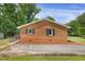 Brick home's exterior showcases a well-maintained yard, black shutters, and a serene setting at 207 Mcleod Dr, Sanford, NC 27330
