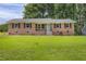 Charming brick home featuring a well-manicured lawn and a vibrant blue front door at 207 Mcleod Dr, Sanford, NC 27330