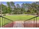 Pathway leads to a home with lush front lawn and a tranquil pond view at 207 Mcleod Dr, Sanford, NC 27330