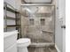 Shower featuring gray tile, built-in niche, a glass door and a bench seat at 207 Mcleod Dr, Sanford, NC 27330