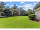 Lush green backyard featuring a well-maintained lawn and mature trees at 207 N Hopkins Ave, Spring Hope, NC 27882
