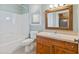 Bathroom with a wooden-framed mirror, and a white sink, toilet and shower-tub at 207 N Hopkins Ave, Spring Hope, NC 27882