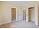Bedroom with neutral walls and carpet, with open doors to closet and bathroom at 207 N Hopkins Ave, Spring Hope, NC 27882