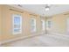 Spacious bedroom with neutral carpet, three large windows and a ceiling fan at 207 N Hopkins Ave, Spring Hope, NC 27882