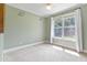 Carpeted bedroom with light green walls, a ceiling fan, and a large window with white curtains at 207 N Hopkins Ave, Spring Hope, NC 27882