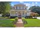 Inviting two-story house with a spacious porch, landscaped front yard, and brick pathway at 207 N Hopkins Ave, Spring Hope, NC 27882