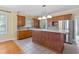 Traditional kitchen with stainless steel appliances, tile floors, wood cabinets, and a breakfast bar with elegant lighting at 207 N Hopkins Ave, Spring Hope, NC 27882
