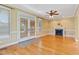 Bright living room with hardwood floors, a ceiling fan, fireplace, and access to the porch at 207 N Hopkins Ave, Spring Hope, NC 27882