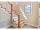 Bright foyer with wooden staircase, white banisters, tile floor, and natural light from two windows at 207 N Hopkins Ave, Spring Hope, NC 27882