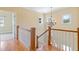 Staircase landing featuring hardwood floors, white banisters, and decorative chandelier at 207 N Hopkins Ave, Spring Hope, NC 27882