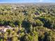 Wide aerial shot showcasing a neighborhood nestled among lush green trees and clear blue sky above at 241 E Cornwall Rd, Cary, NC 27511