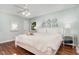 Bright bedroom with a large bed, hardwood floors, and a decorative ceiling fan at 241 E Cornwall Rd, Cary, NC 27511