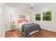 Cozy bedroom featuring a large bed, hardwood floors, ceiling fan, and view from large window at 241 E Cornwall Rd, Cary, NC 27511