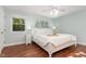Bright bedroom with a large bed, hardwood floors, and a decorative ceiling fan at 241 E Cornwall Rd, Cary, NC 27511
