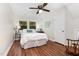 Cozy bedroom with wood floors, a ceiling fan, and natural light from the window at 241 E Cornwall Rd, Cary, NC 27511