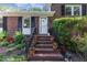 Brick home with an inviting front porch, decorative plants, and charming entrance at 241 E Cornwall Rd, Cary, NC 27511