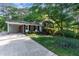 Brick home featuring a carport and a well-manicured lawn with lovely landscaping at 241 E Cornwall Rd, Cary, NC 27511