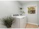 Bright laundry room with a window, shelving, tile floor, and a modern washer and dryer at 241 E Cornwall Rd, Cary, NC 27511