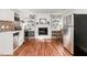 Open concept living area featuring a kitchen with stainless steel appliances, fireplace, and hardwood floors at 241 E Cornwall Rd, Cary, NC 27511