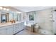 Bright bathroom featuring double vanity, soaking tub under window, and tile and glass shower at 241 Tidal Pool Way, Cary, NC 27519