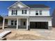 New construction home with white siding, stone accents, and an attached two-car garage at 241 Tidal Pool Way, Cary, NC 27519